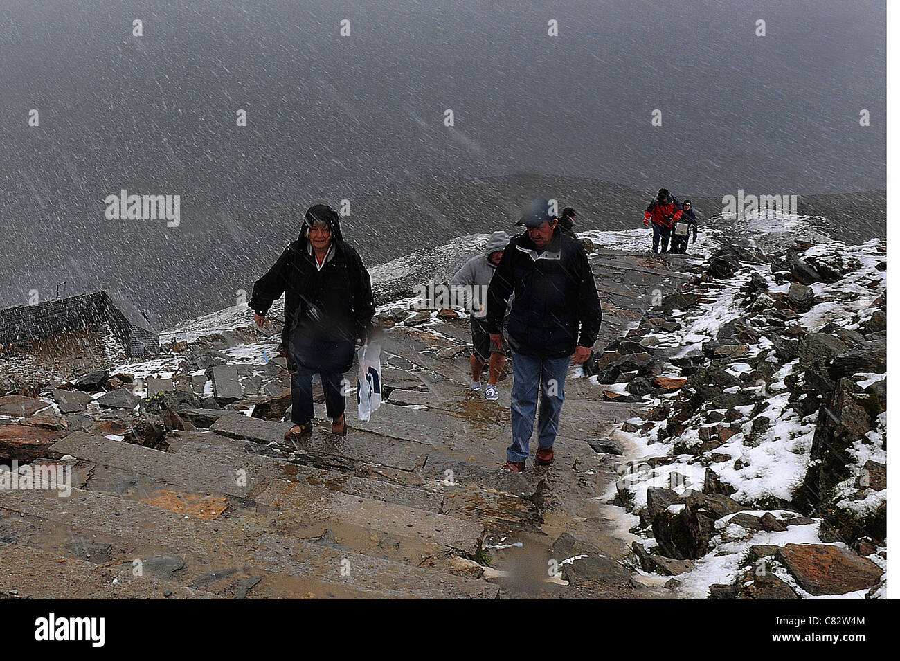 TOURISTS ARE CAUGHT OUT BY A SUMMER BLIZZARD AT THE SUMMIT OF MOUNT SNOWDON, WALES Stock Photo