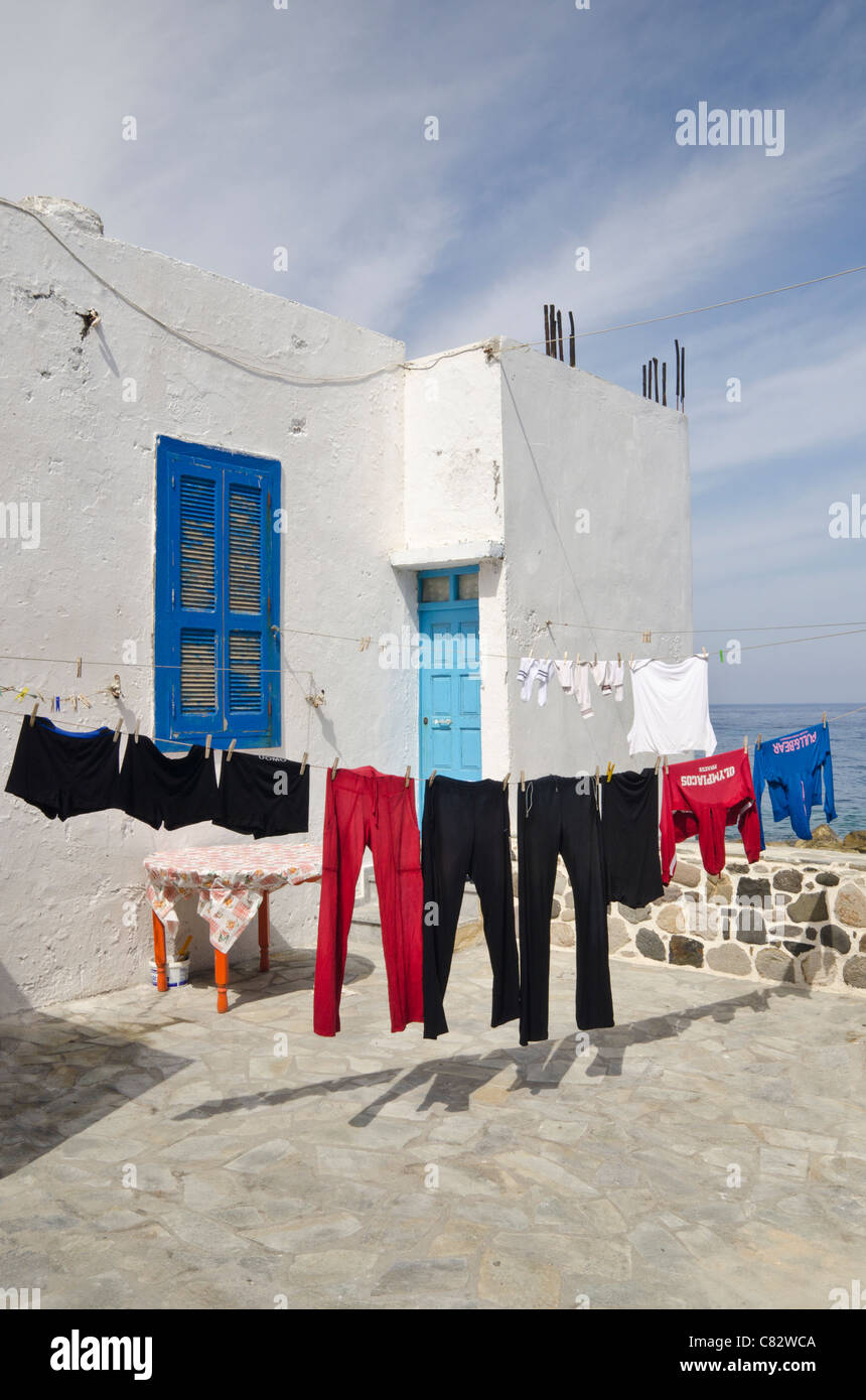 Washing on a line in front of a white washed house in Greece Stock Photo