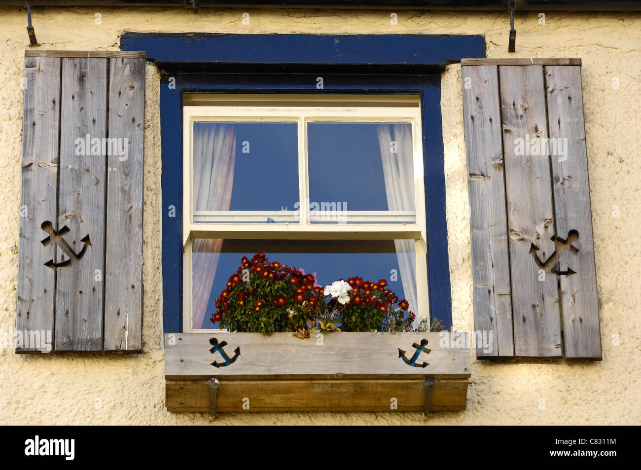 Wooden window box and shutters with a shape of a anchor carved into