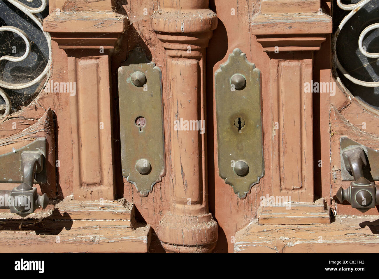 Detail of a Brown Wood Window Door with Weathered Brass Handles Stock Photo