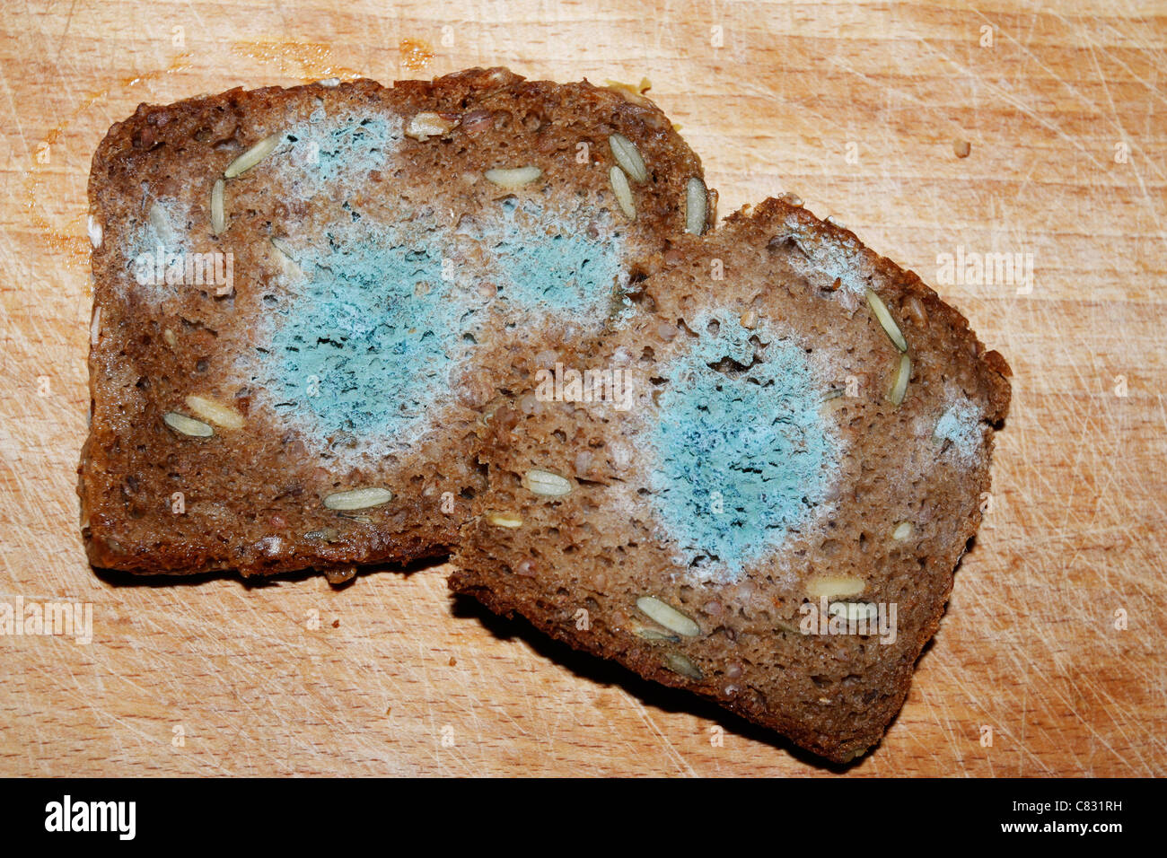 Mouldy toxic bread on wooden board Stock Photo
