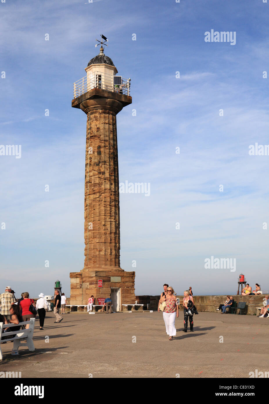 People walking near the lighthouse on Whitby pier Stock Photo