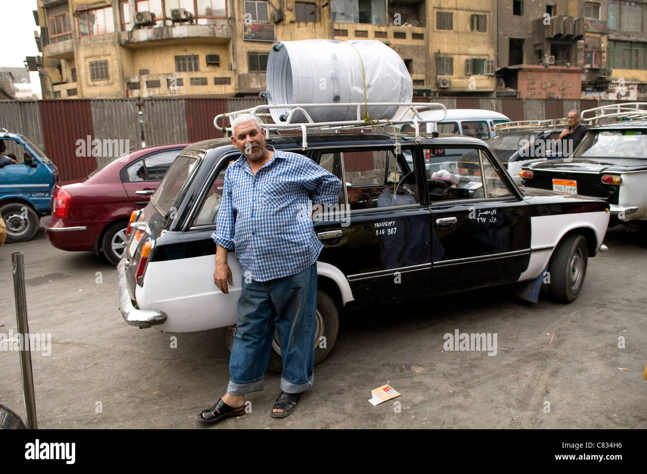 An Egyptian taxi driver standing by his old taxi in Cairo Stock Photo