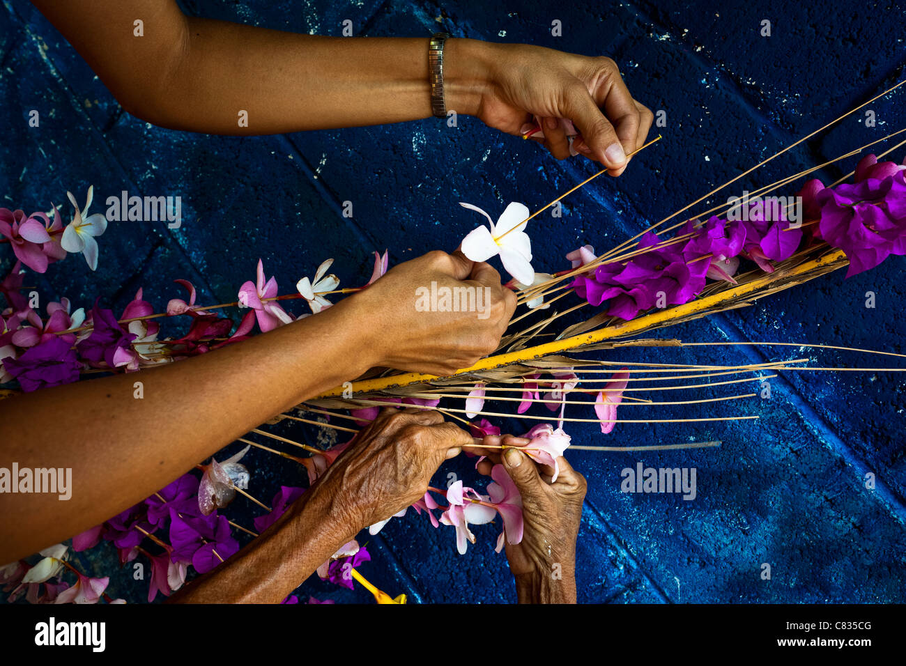 Salvadoran women work on a floral ornament during the Flower & Palm Festival in Panchimalco, El Salvador. Stock Photo
