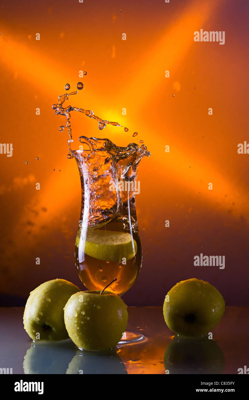 green apples and glass with juice on a glass table Stock Photo - Alamy