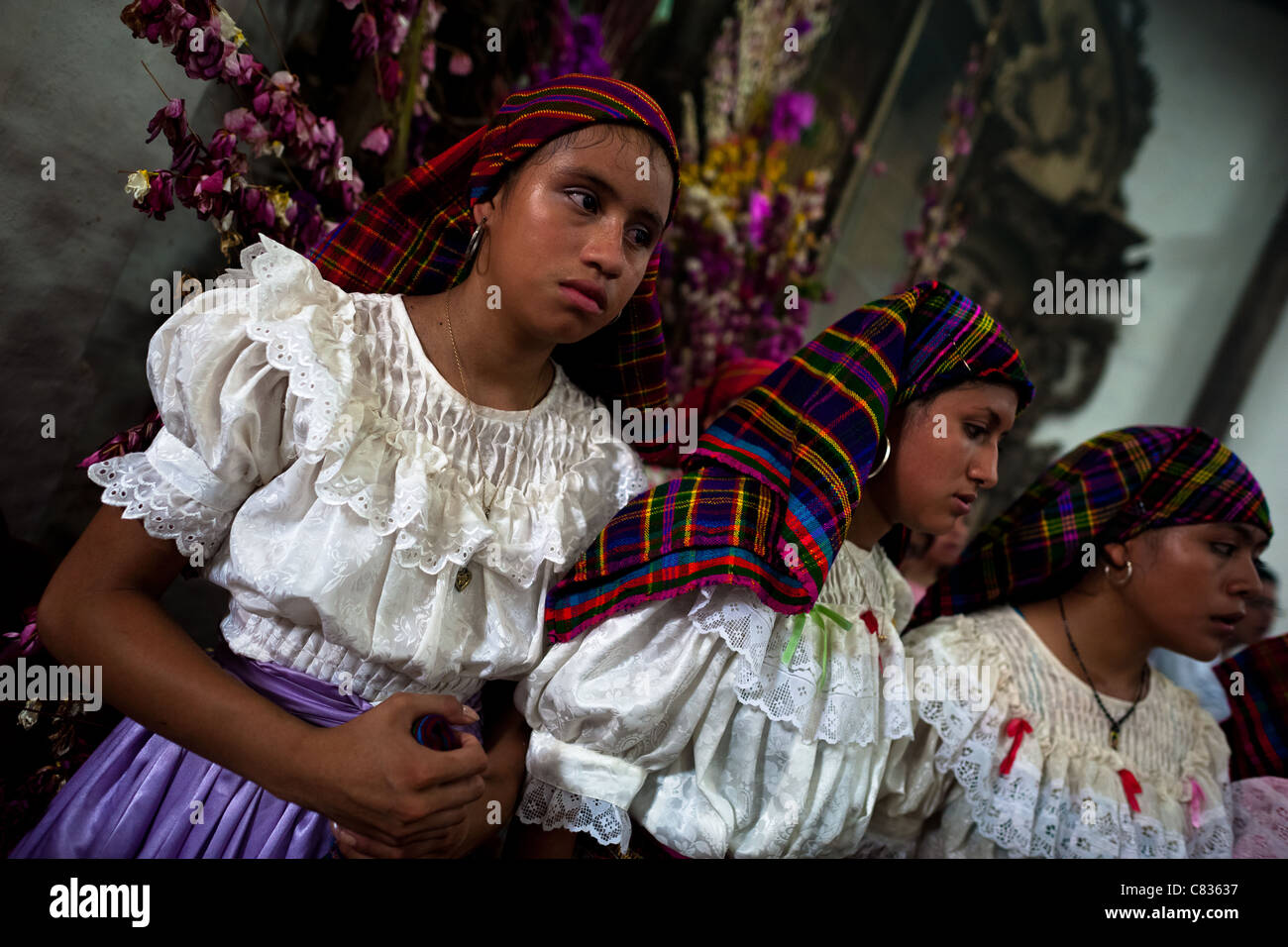 Salvadoran girls pray during the Holy Mass at the end of the Flower & Palm Festival in Panchimalco, El Salvador. Stock Photo
