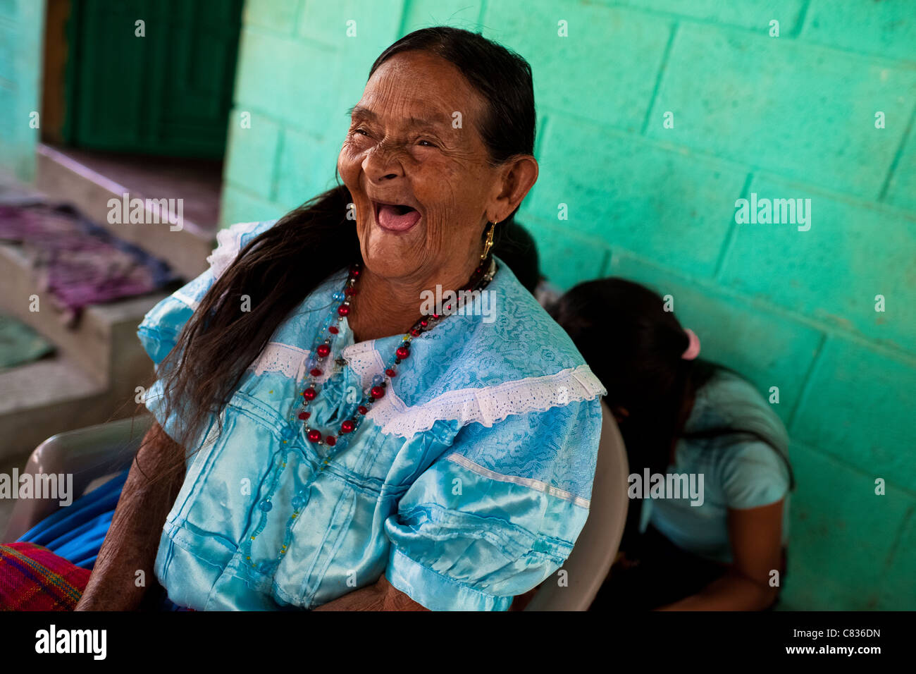 An old Salvadoran woman laughs, while watching the procession of the Flower & Palm Festival in Panchimalco, El Salvador. Stock Photo