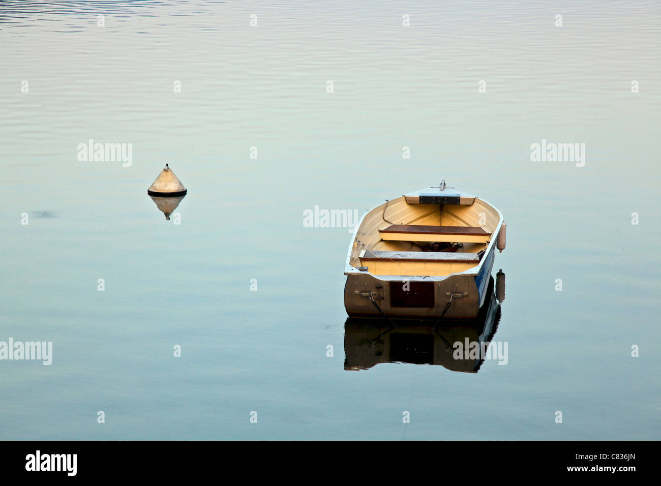 A light rowing boat moored in the middle of a lake on still water Stock ...