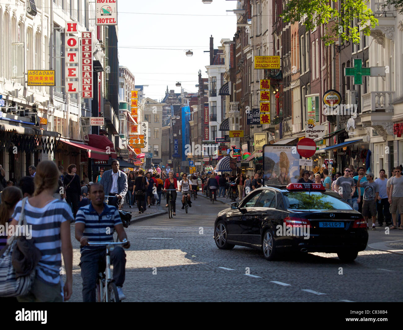 Damstraat Dam street with many people and taxi in Amsterdam, the Netherlands Stock Photo
