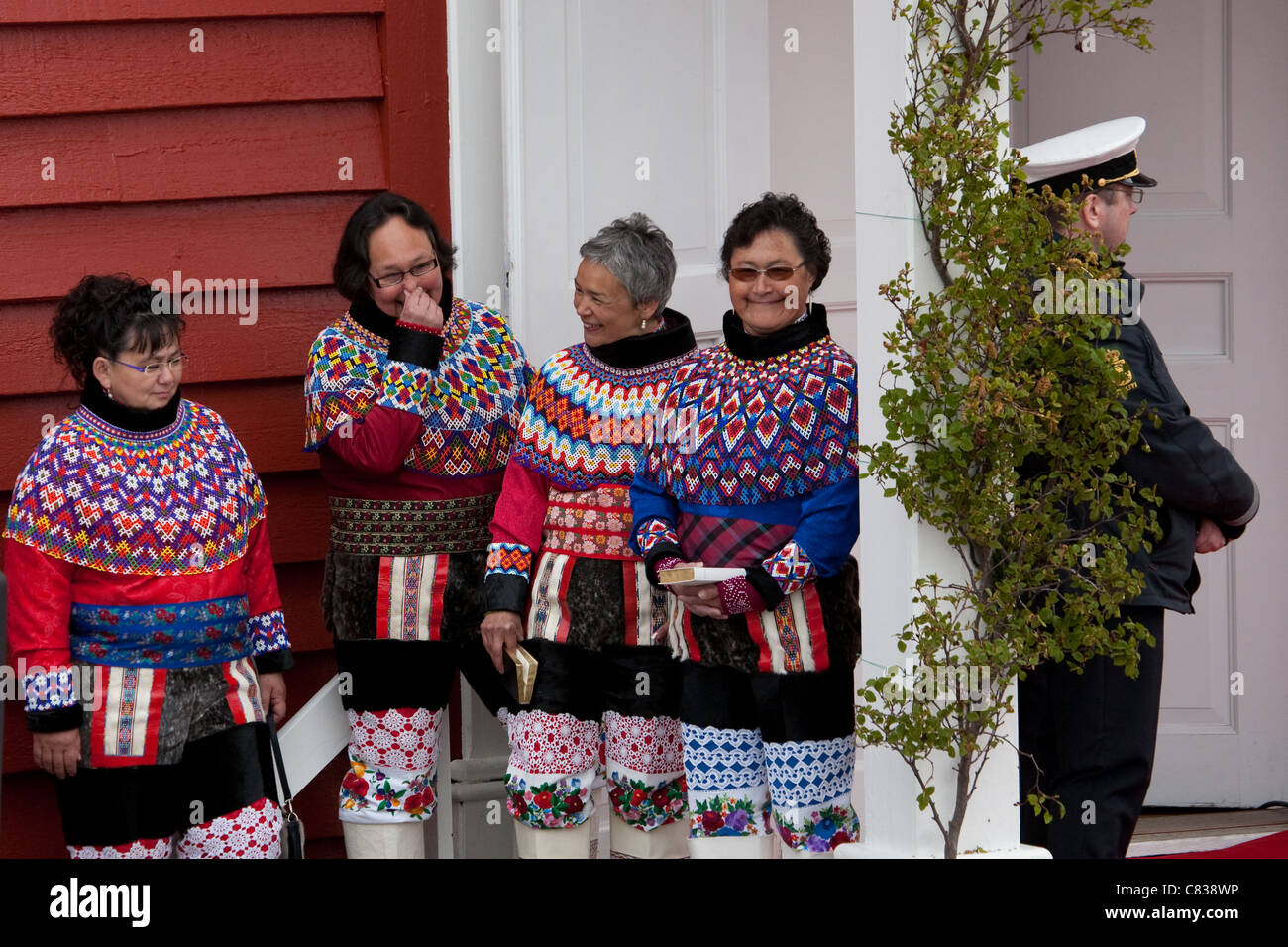 Inuit women sharing a giggle outside Cathedral Annaassisitta Oqaluffia, Nuuk on Greenland's National Day. Stock Photo