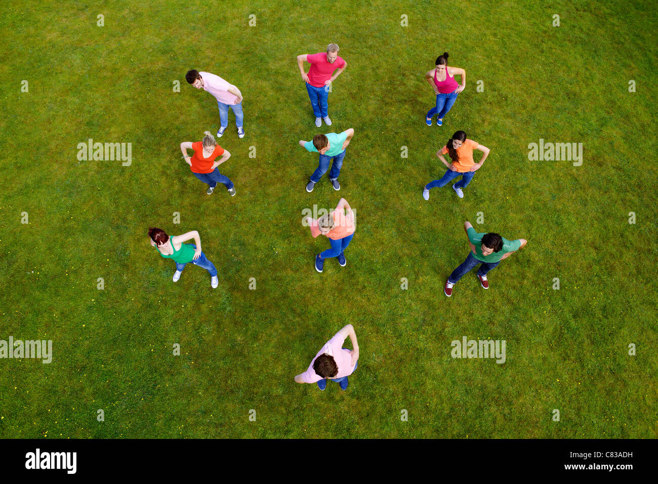 People stretching together in grass Stock Photo