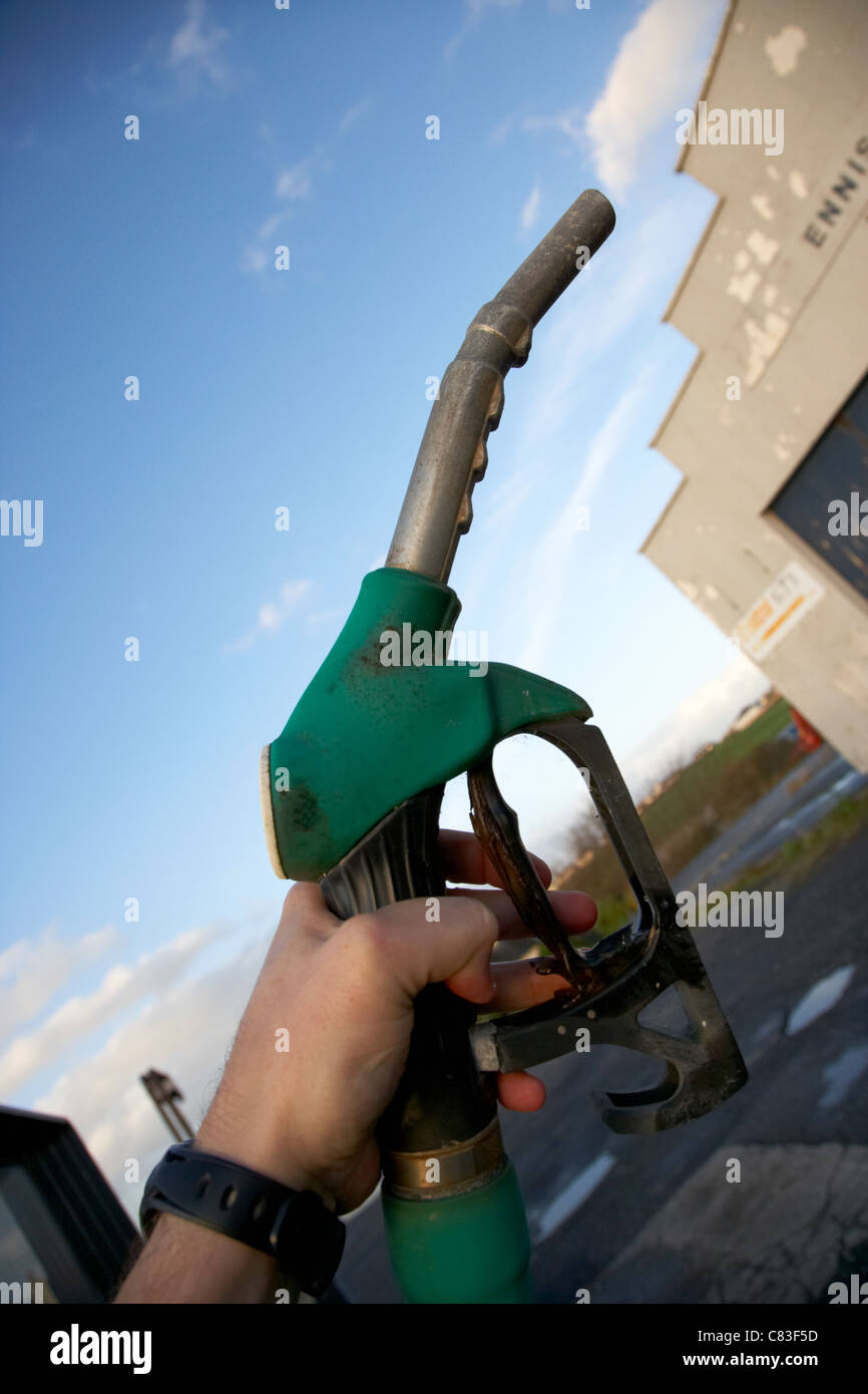 mans hand holding unleaded petrol pump nozzle Stock Photo
