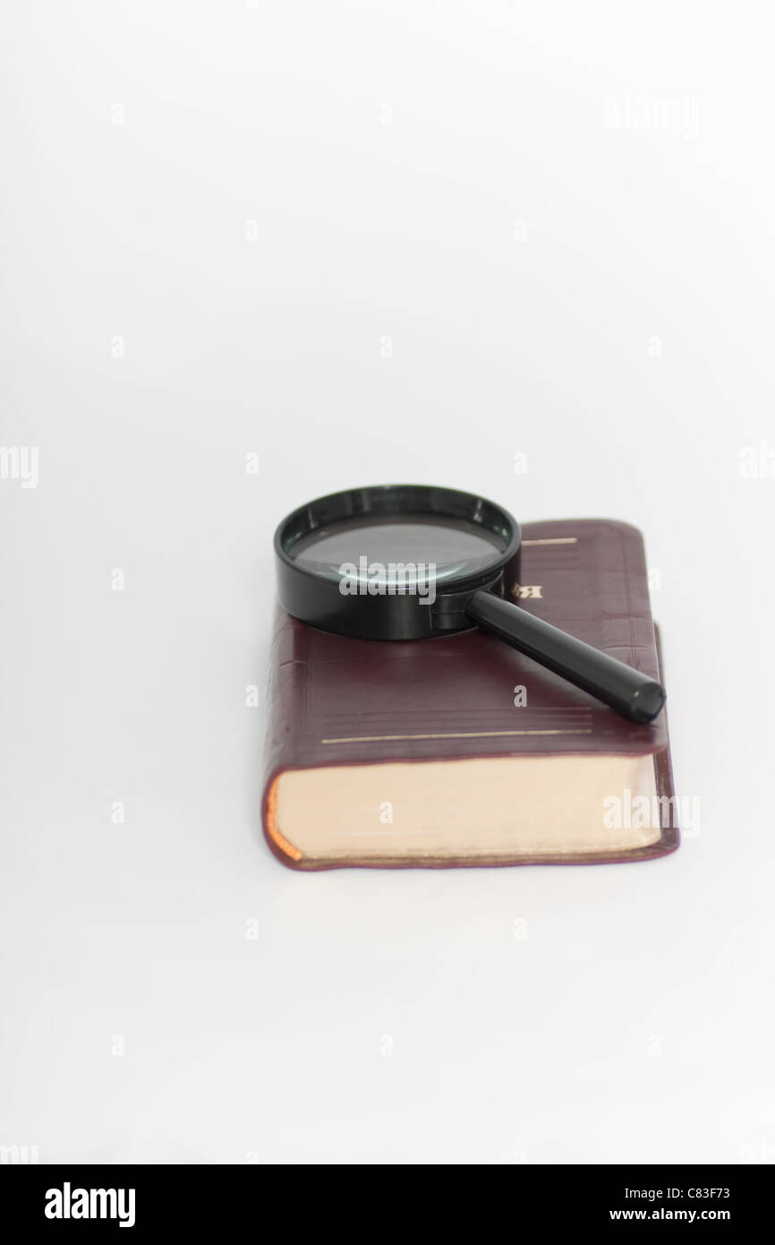 Magnifying glass on book Stock Photo - Alamy