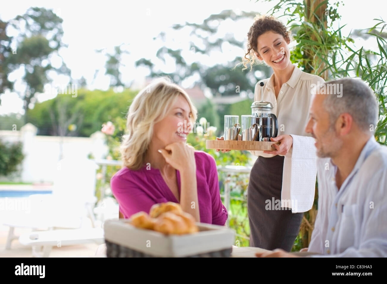 Waitress serving coffee to couple Stock Photo Alamy