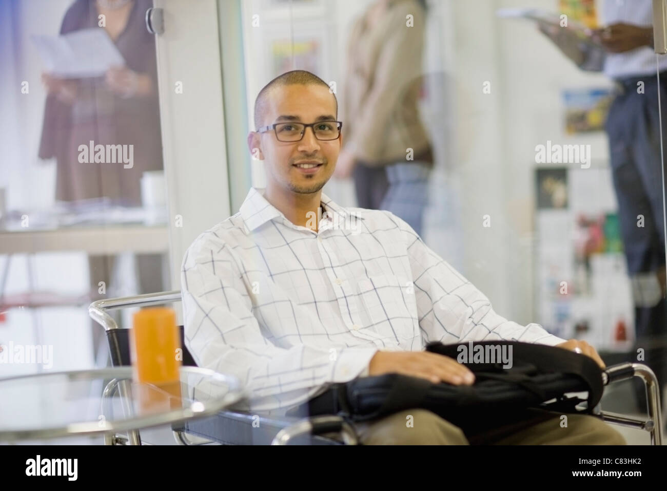 Smiling businessman sitting in office Stock Photo - Alamy