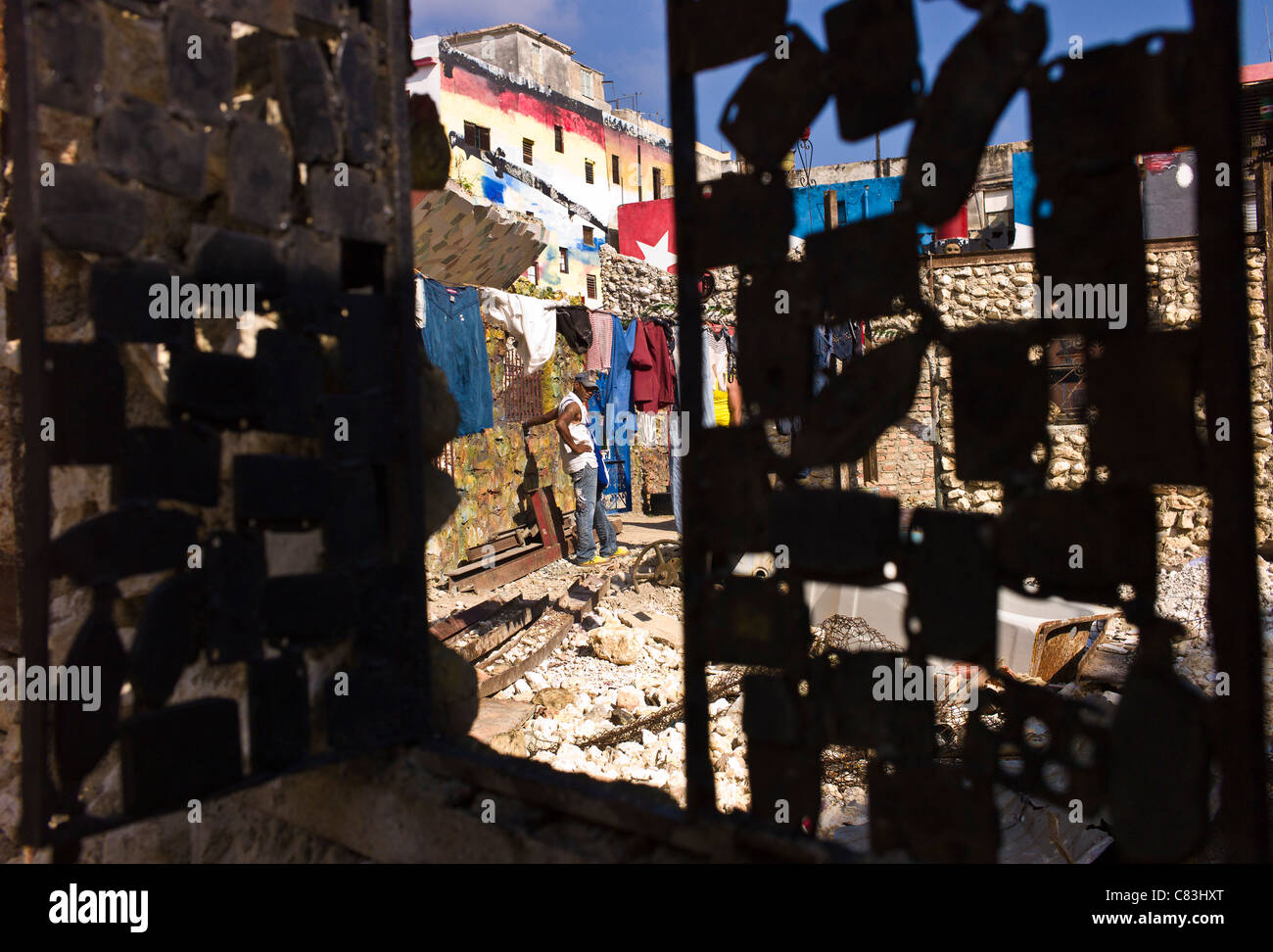 View through the door (made from recycled metal scrap) into a courtyard of buildings decorated by the local artists. Stock Photo