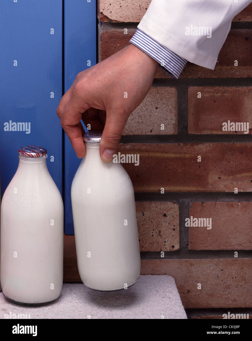 Milkman delivering milk on a doorstep Stock Photo Alamy