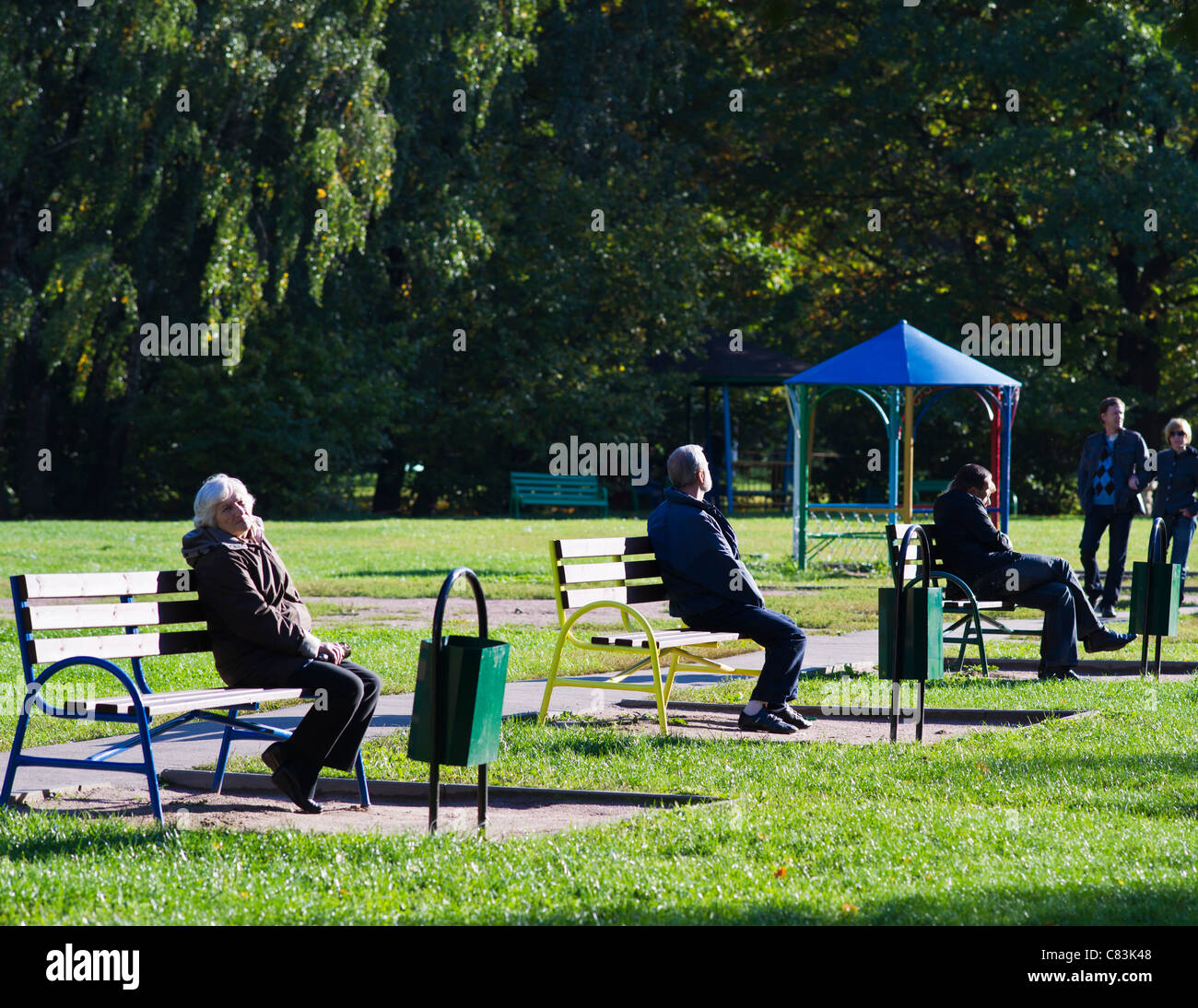 People Are Sitting On The Benches In A Row One By One Enjoying The