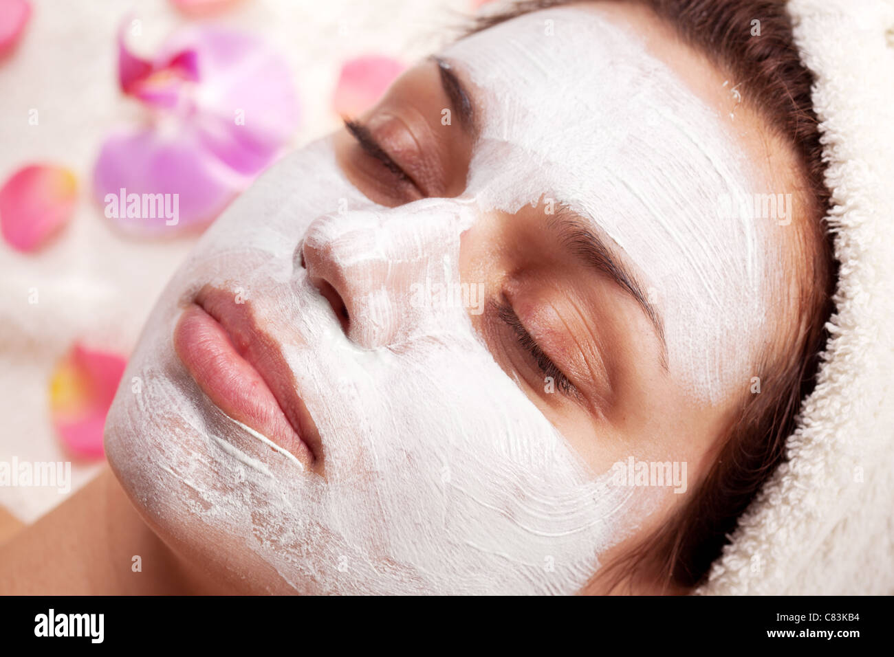 Young woman with cosmetic mask on her face. Stock Photo
