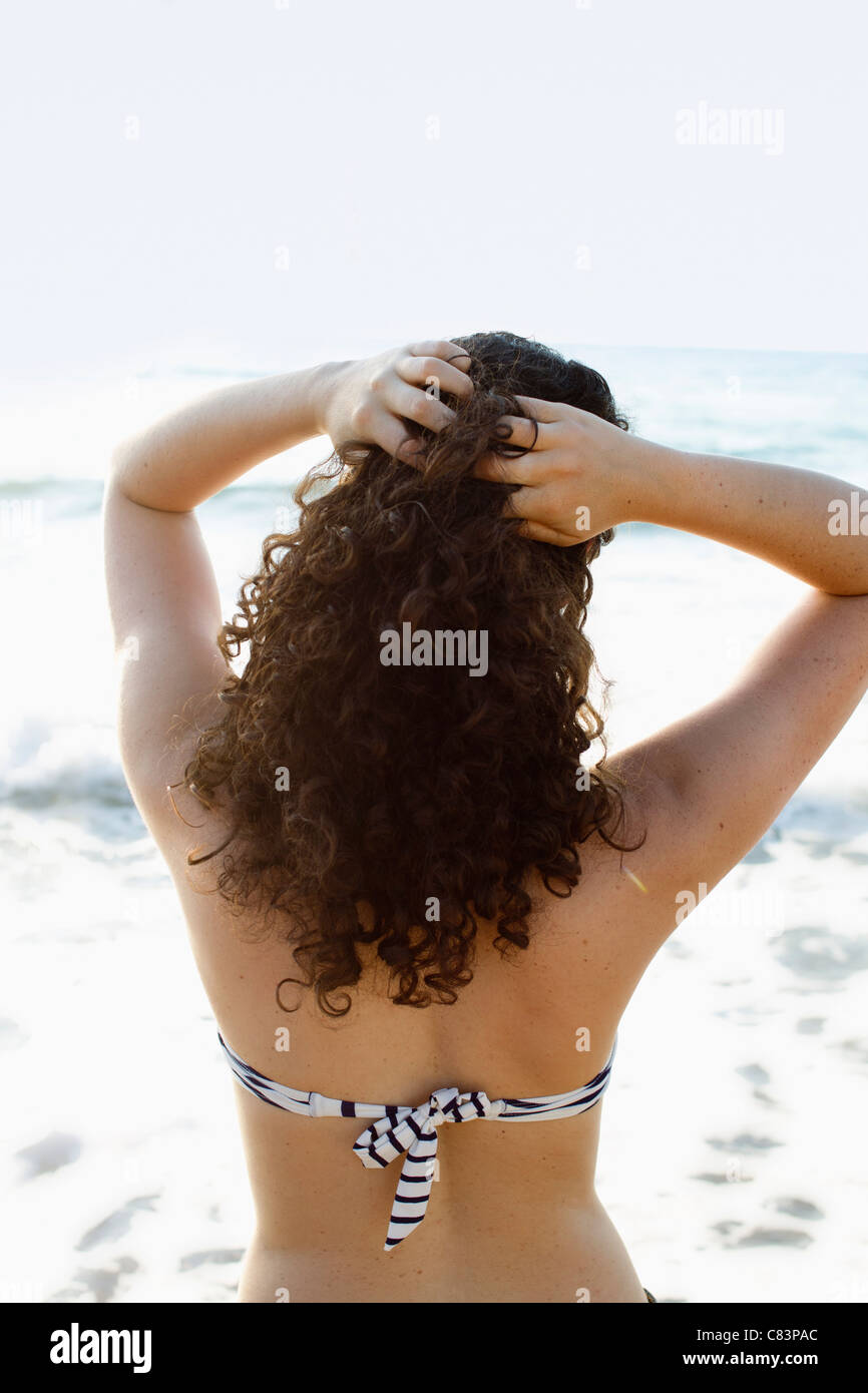 Woman in bikini standing on beach Stock Photo