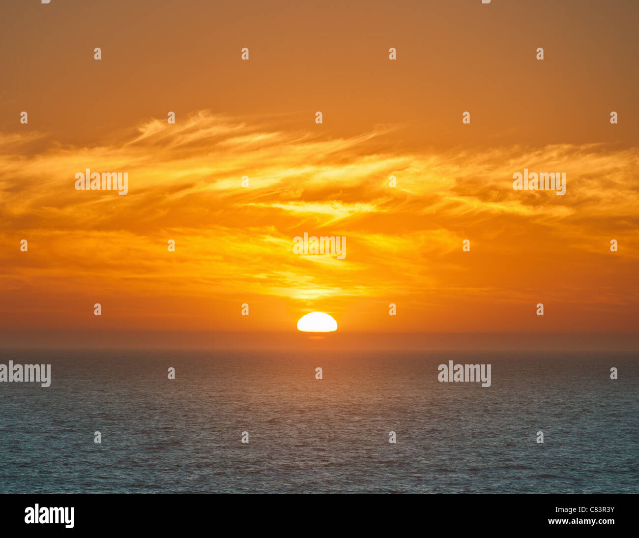 Sun setting over horizon Stock Photo