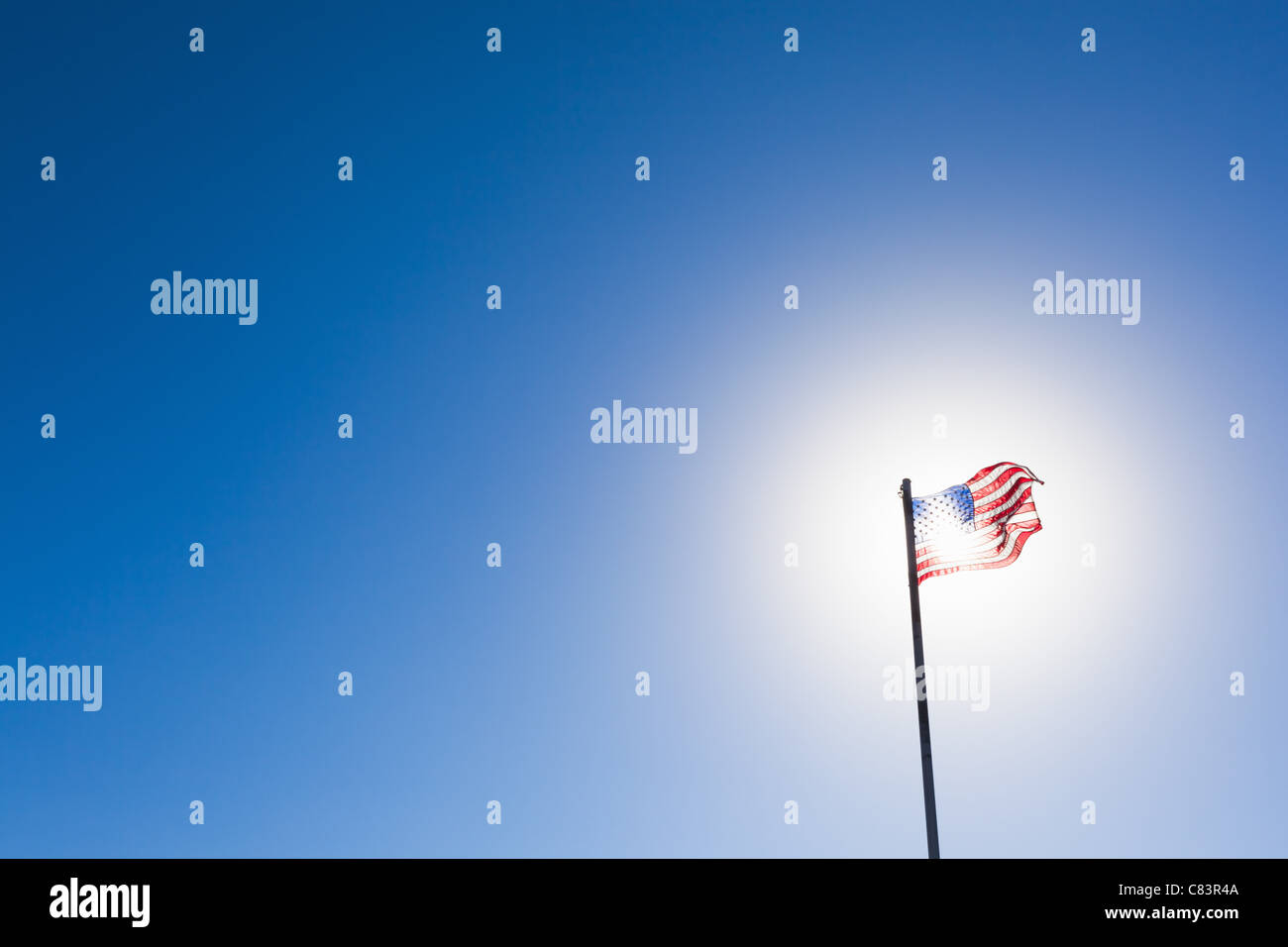 American flag against sun and blue sky Stock Photo - Alamy