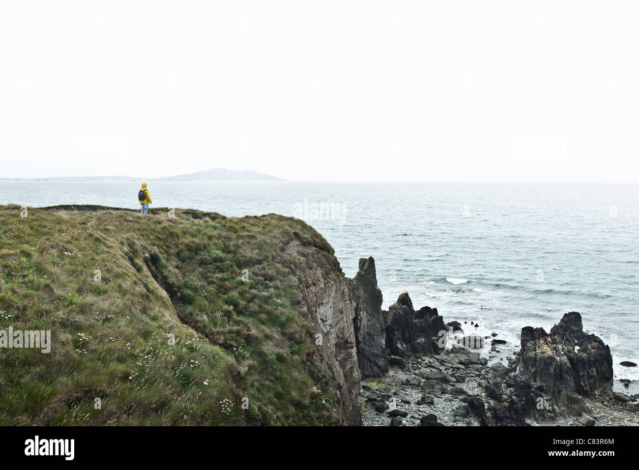Hiker overlooking ocean from cliff Stock Photo Alamy