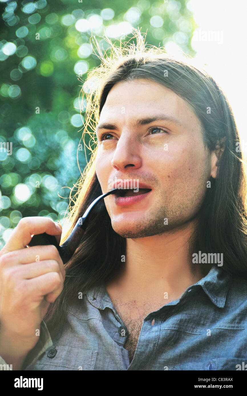 Man smoking pipe outdoors Stock Photo