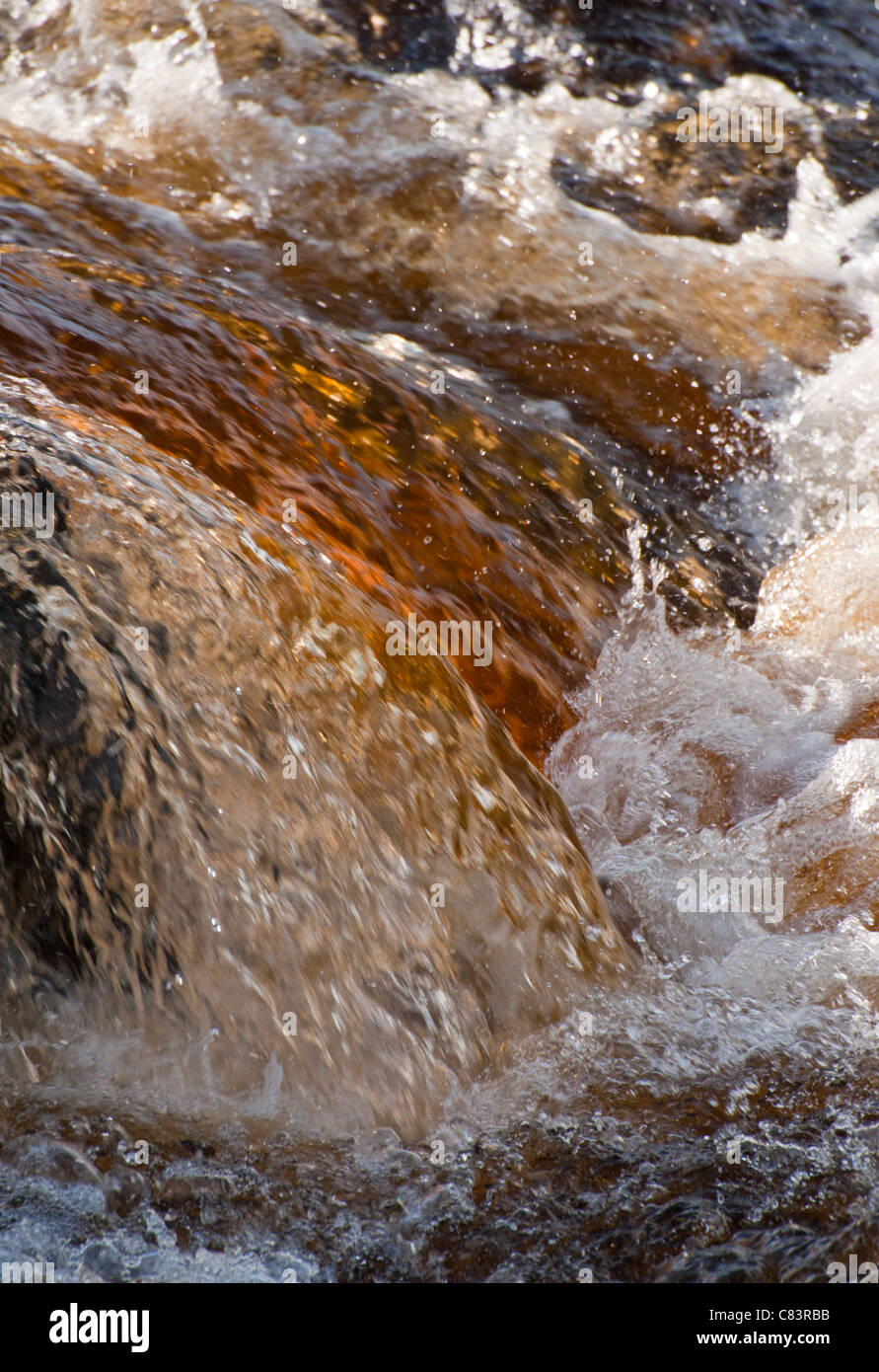 Peaty coloured water running down the River Garry in Perthshire Stock Photo