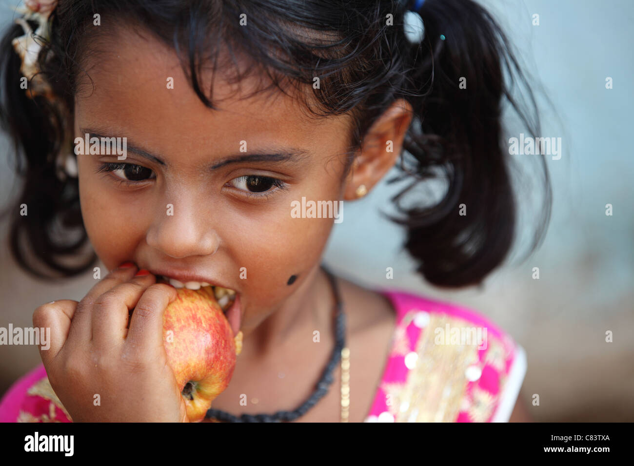 Young girl eating an apple Andhra Pradesh South India Stock Photo - Alamy