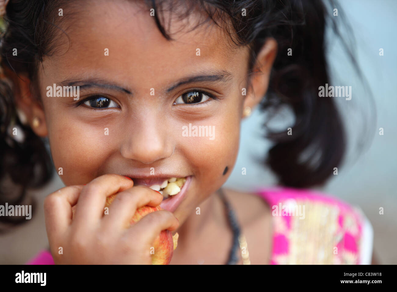 Young girl eating an apple Andhra Pradesh South India Stock Photo - Alamy