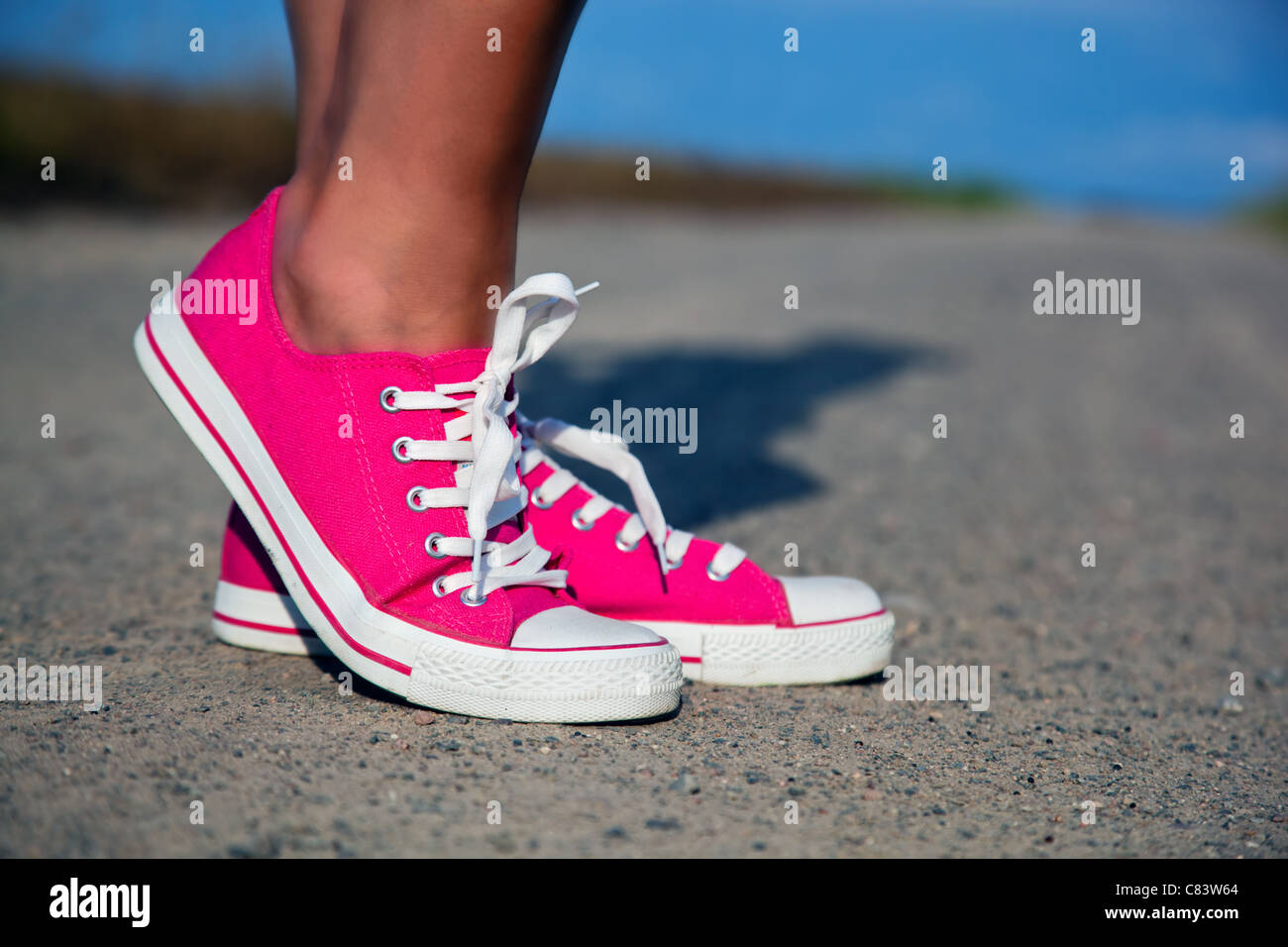 Pink sneakers on girl, young woman legs, outdoors Stock Photo - Alamy