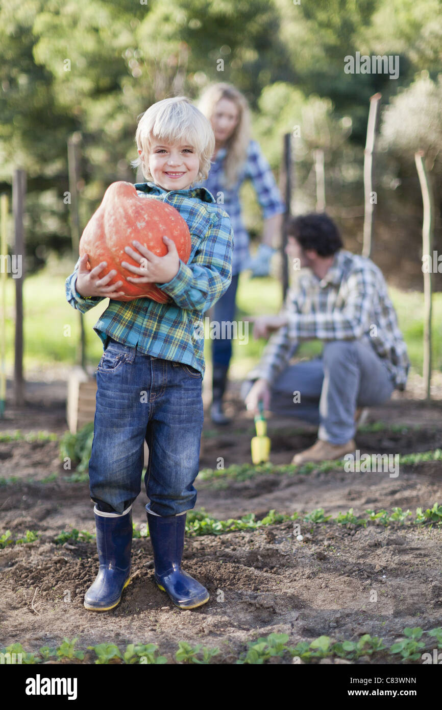 Boy carrying gourd in garden Stock Photo Alamy