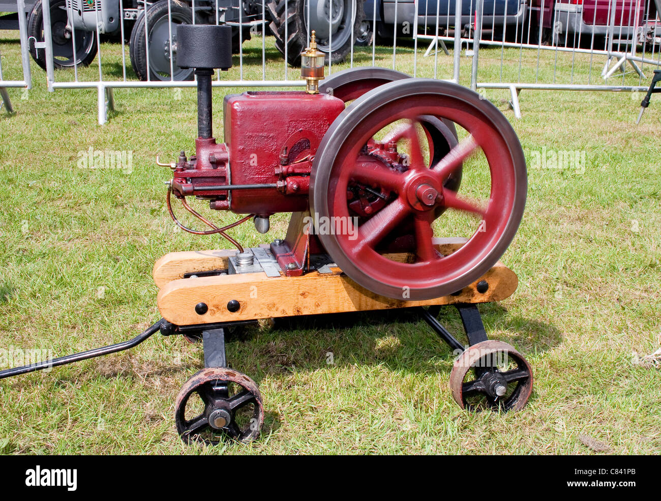Vintage Restored Red Stationary Engine with Spinning Flywheel Stock Photo