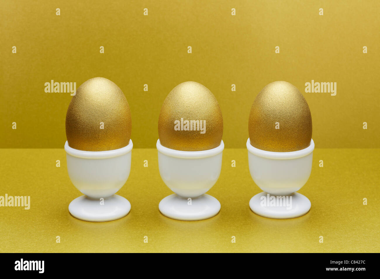 Golden eggs in egg cups Stock Photo