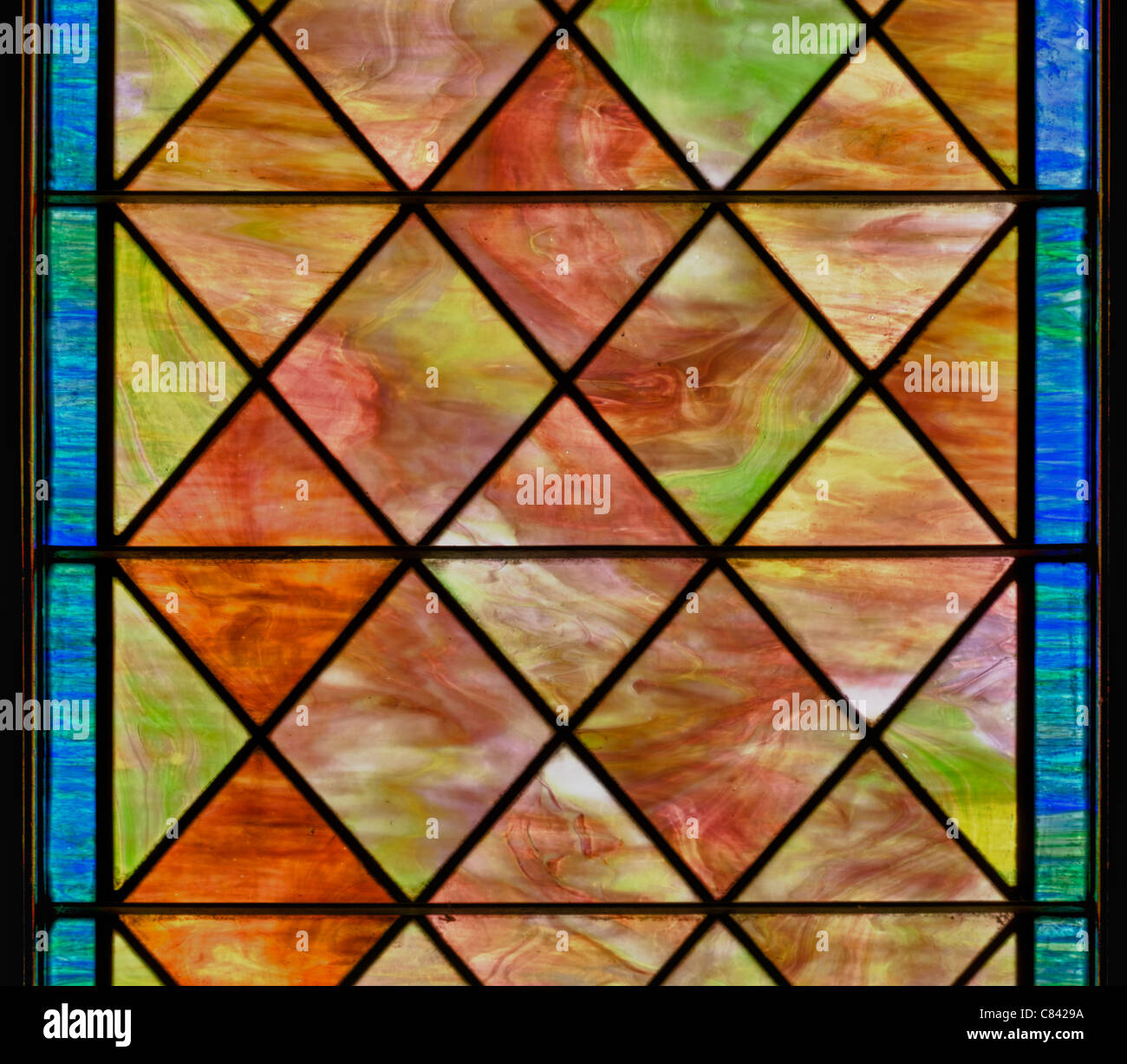 Stained glass window with diamond shapes and overall red brown color Stock Photo