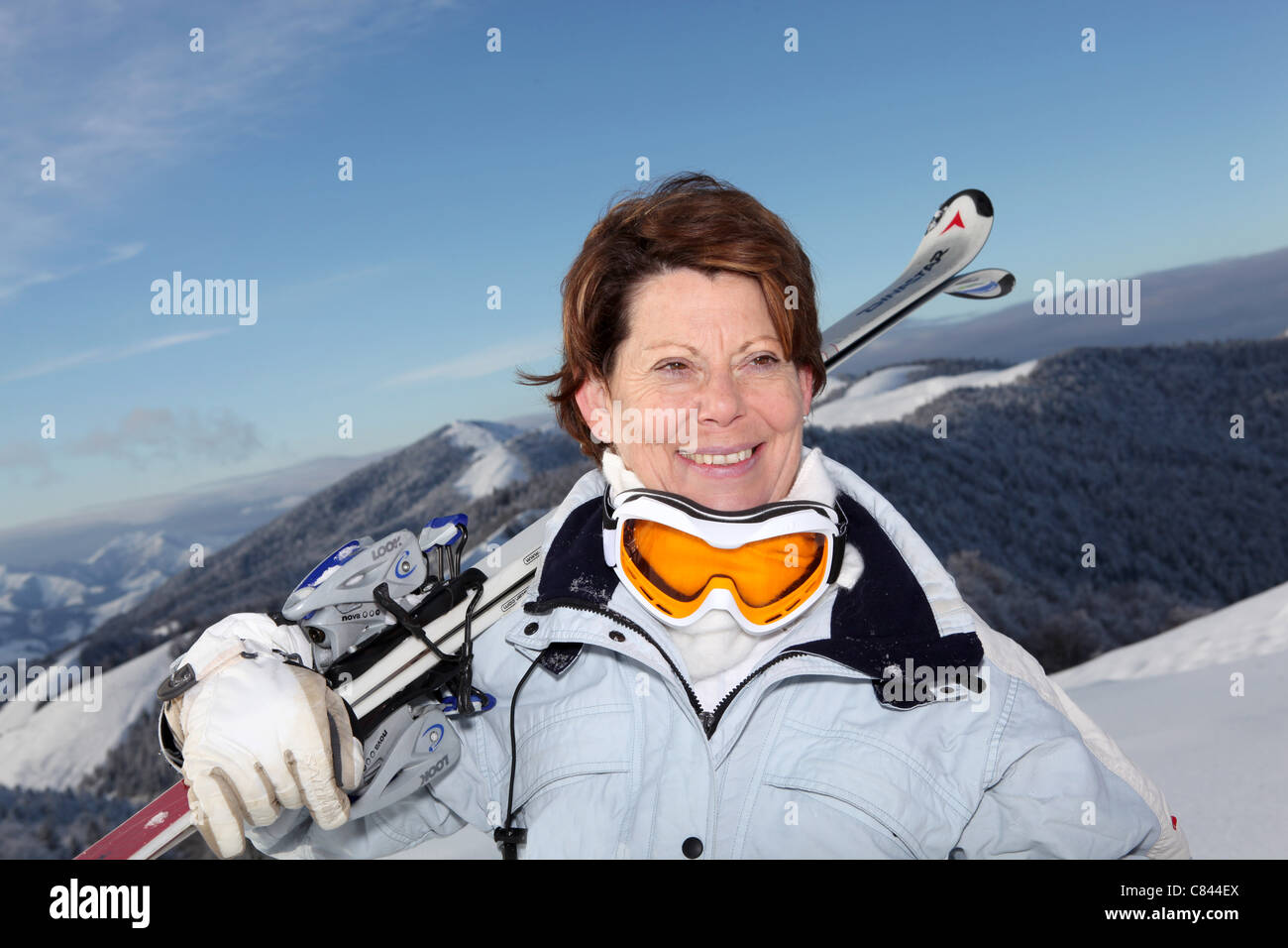 Middle-aged woman skiing on mountain Stock Photo