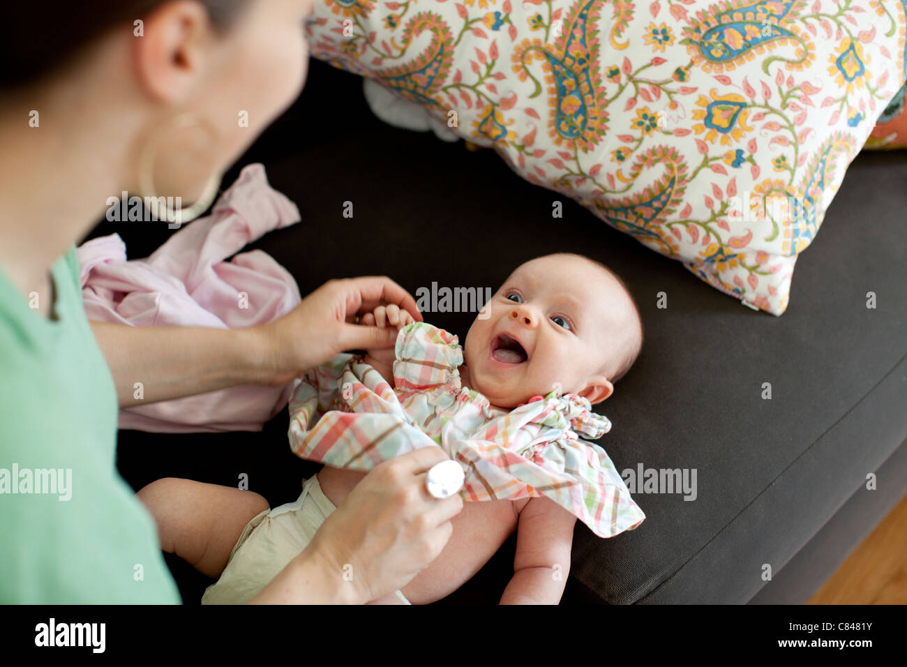 Caucasian mother changing baby daughter's clothes Stock Photo Alamy