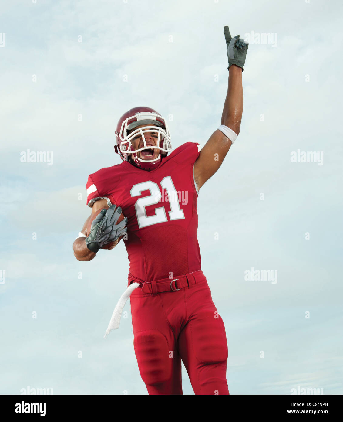 Black football player carrying football making number 1 gesture Stock Photo