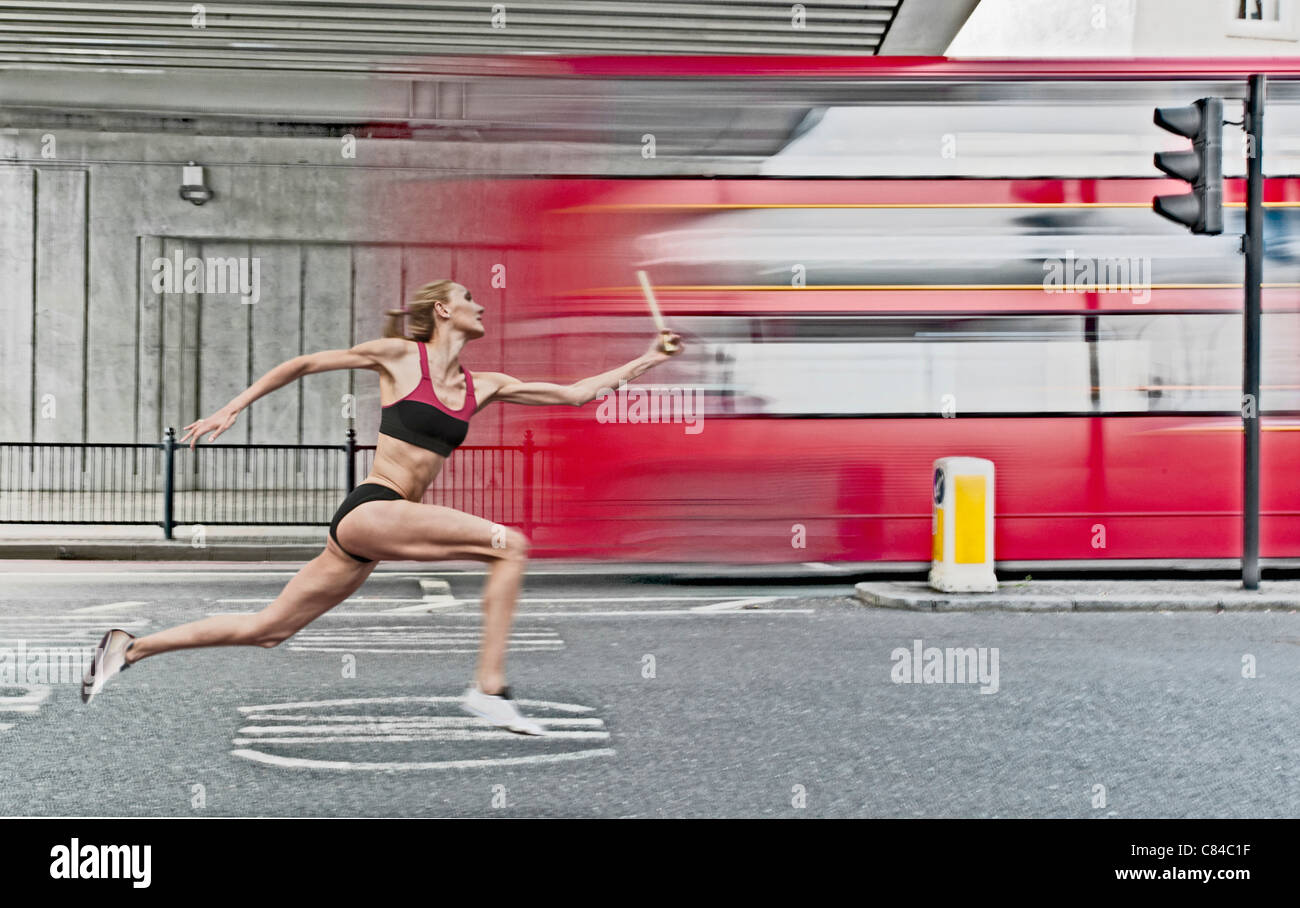 Athlete carrying baton on city street Stock Photo Alamy