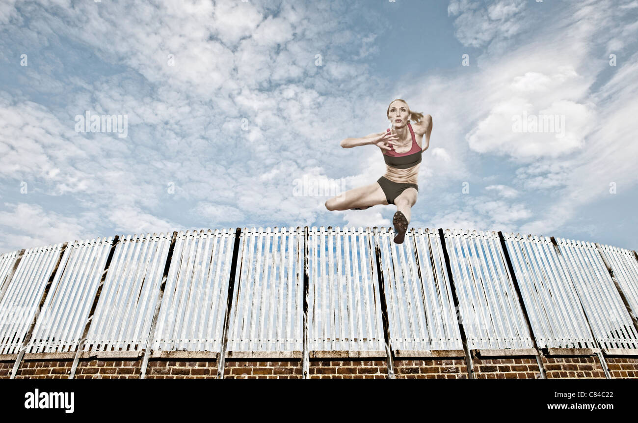 Athlete jumping over fence Stock Photo Alamy