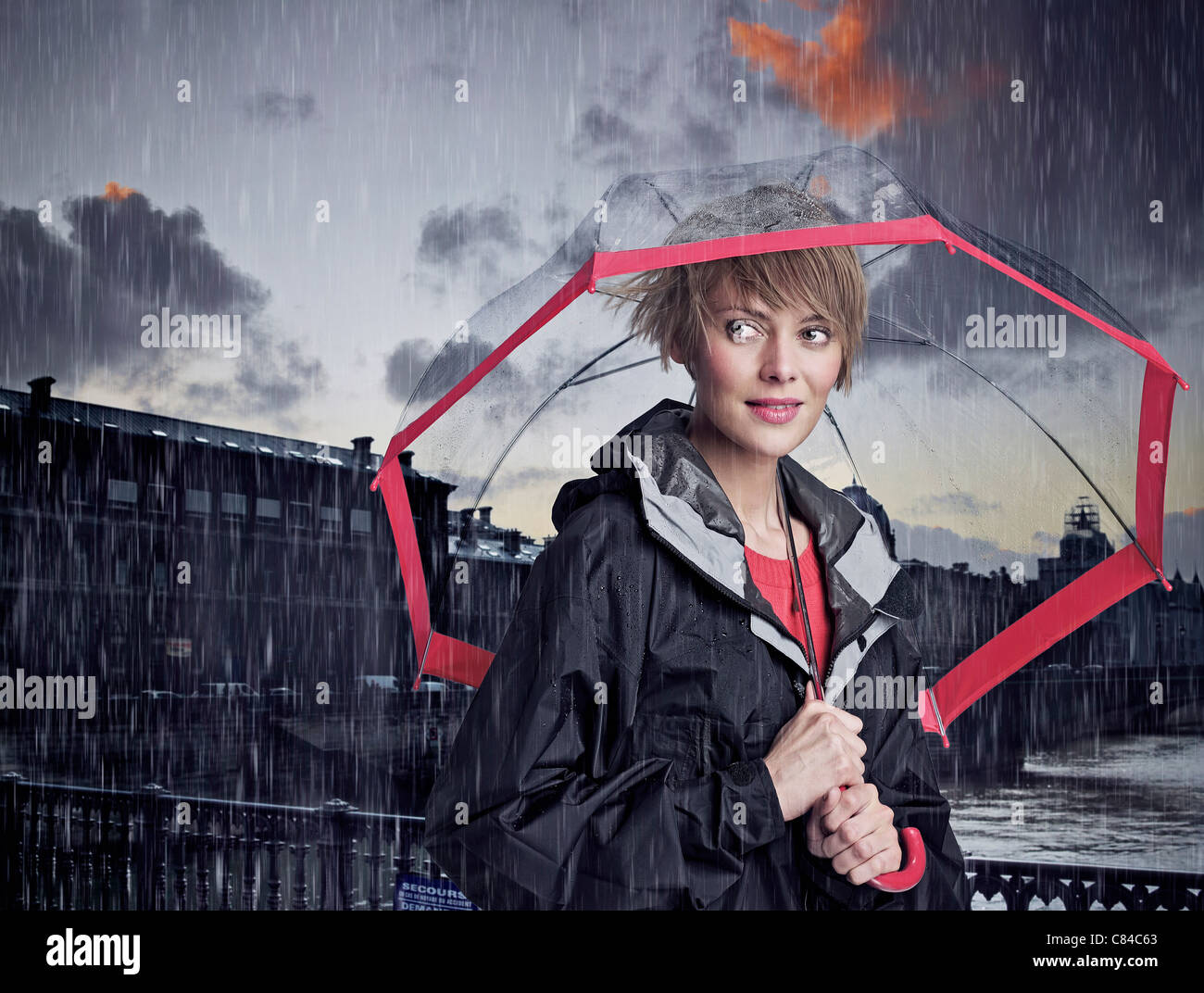 Woman walking under umbrella in rain Stock Photo
