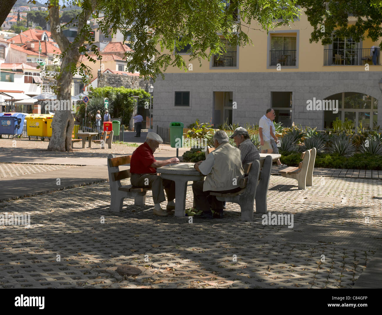 Elderly local islanders senior people playing dominoes game on an outside outdoors table bench Funchal Madeira Portugal EU Europe Stock Photo