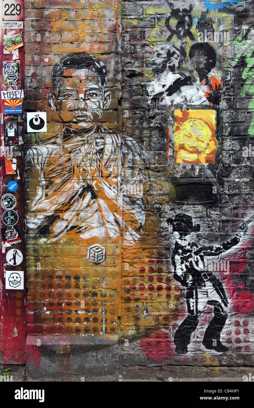 colorful graffiti on brick exterior of squatted building in central Amsterdam, images include Buddha, and a cowboy Stock Photo