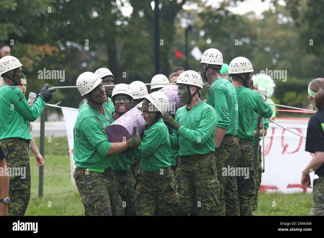 Female and male cadets carrying a heavy log for team building Stock Photo