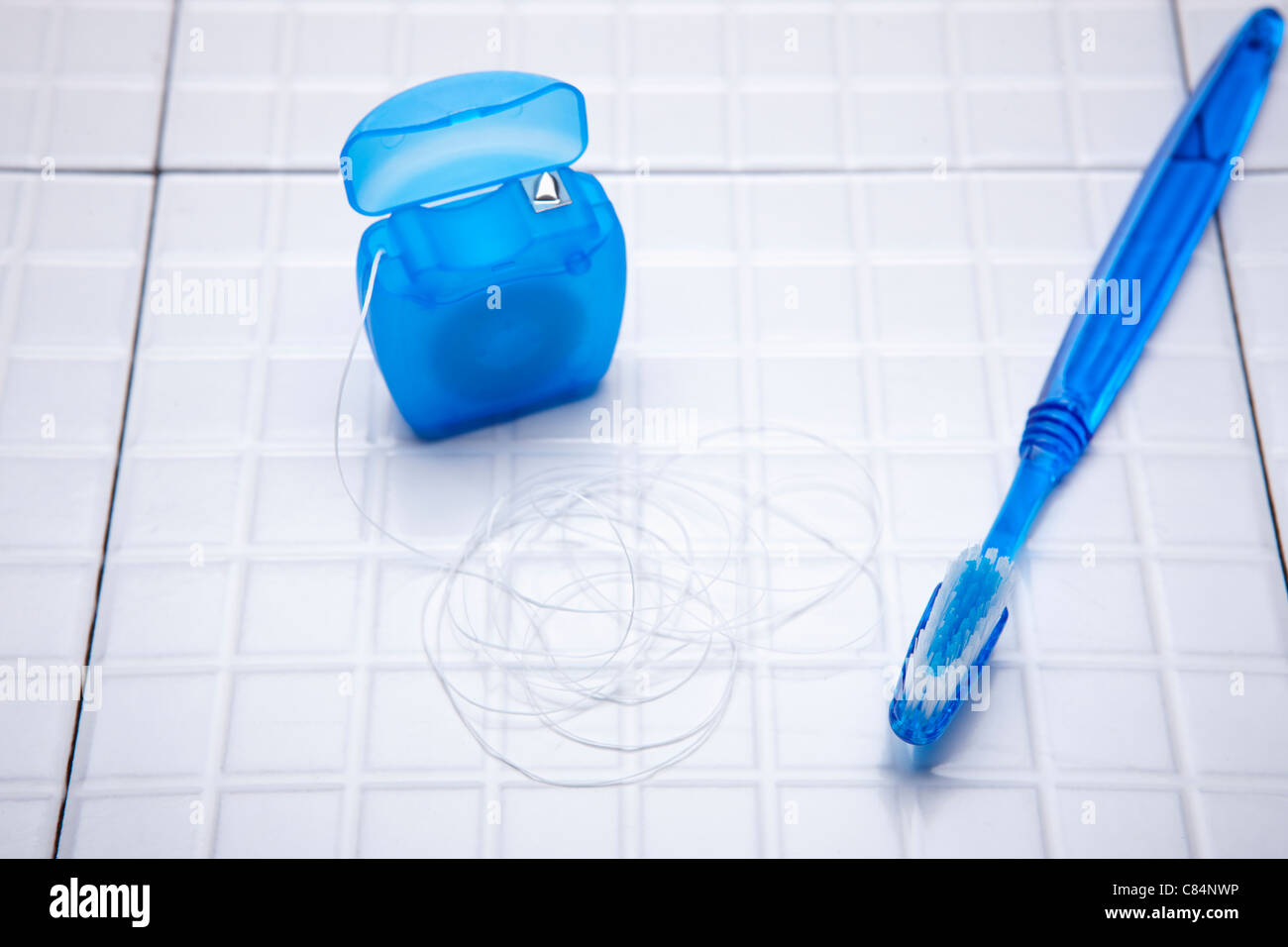 Dental floss and a blue tooth brush Stock Photo - Alamy