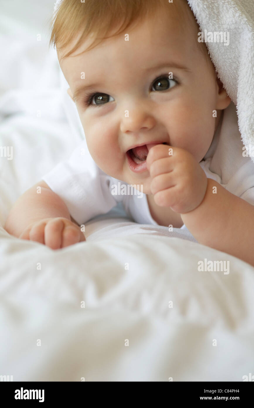 Baby lying on blanket, sticking thumb in mouth, portrait Stock Photo Alamy