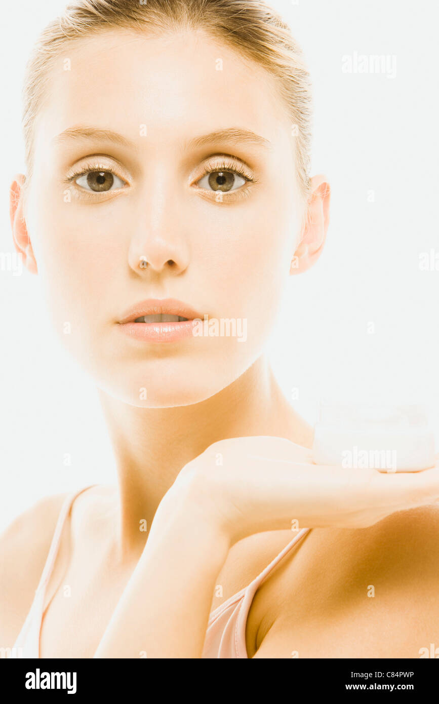 Young woman holding jar of moisturizer, portrait Stock Photo