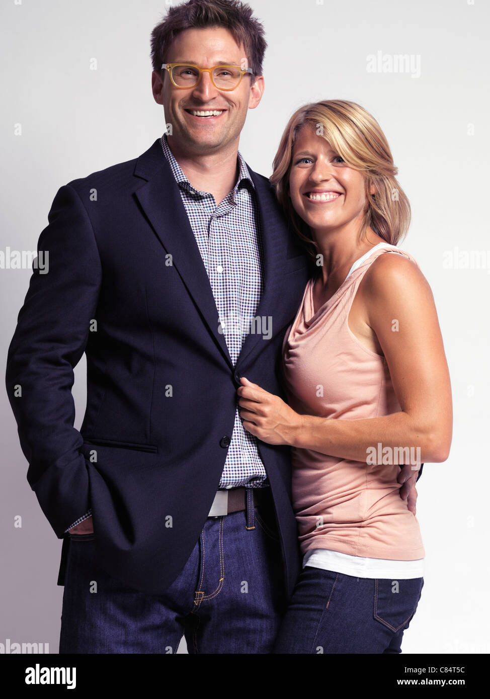 Smiling casually dressed happy young woman and a man isolated on gray background Stock Photo