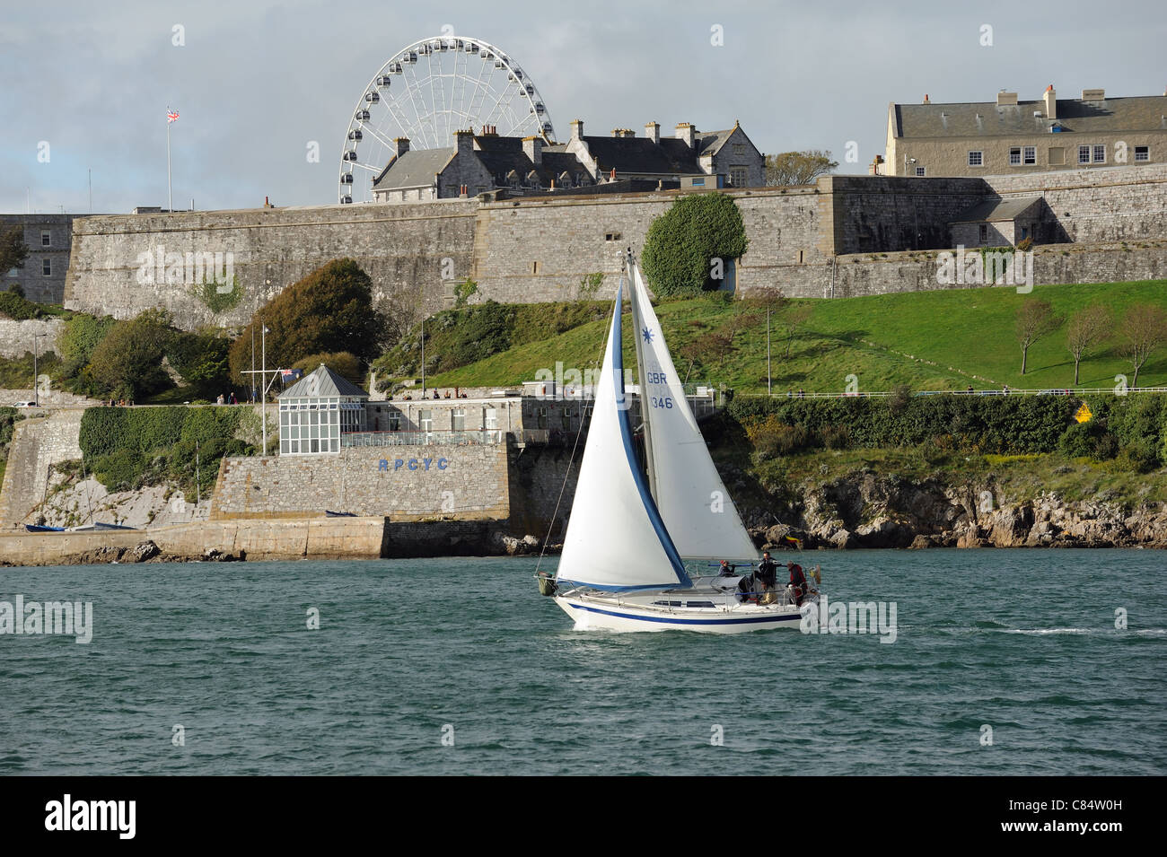 Sailing off the Devonshire coast at Plymouth England UK Yacht passing the historic RPCYC Stock Photo